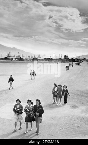 Adolescents, portant des livres, marchant le long de la rue, Manzanar Relocation Center, Californie, , USA, Ansel Adams, Manzanar War Relocation Center Collection, 1943 Banque D'Images