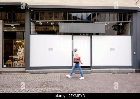 Heidelberg, Allemagne. 29 avril 2021. Un passant passe passe à côté de la fenêtre d'une boutique vide dans la Hauptstraße, une zone piétonne et une rue commerçante dans le centre-ville, couverte de papier d'aluminium blanc. (À dpa: 'Le groupe de travail Heidelberg lutte contre les postes vacants dans le centre-ville') Credit: Uwe Anspach/dpa/Alamy Live News Banque D'Images