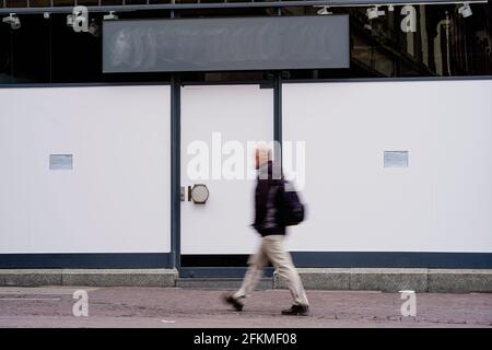 Heidelberg, Allemagne. 29 avril 2021. Un passant passe passe à côté de la fenêtre d'une boutique vide dans la Hauptstraße, une zone piétonne et une rue commerçante dans le centre-ville, couverte de papier d'aluminium blanc. (À dpa: 'Le groupe de travail Heidelberg lutte contre les postes vacants dans le centre-ville') Credit: Uwe Anspach/dpa/Alamy Live News Banque D'Images