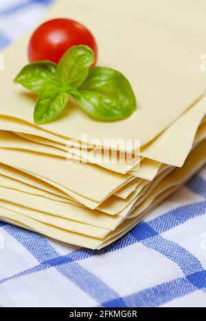 Feuilles de lasagne non cuites, tomate et basilic, pâtes, nouilles Banque D'Images