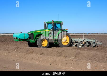 Tracteur John Deere 8120 labourant un champ de coton près de Narrabri, Nouvelle-Galles du Sud, Australie. Un réservoir d'engrais liquide est situé à l'avant du tracteur. Banque D'Images