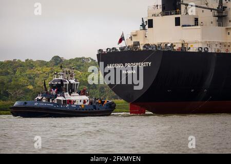 Le navire Legend Prosperity et un remorqueur traversent le canal de Panama, République du Panama, Amérique centrale. Banque D'Images