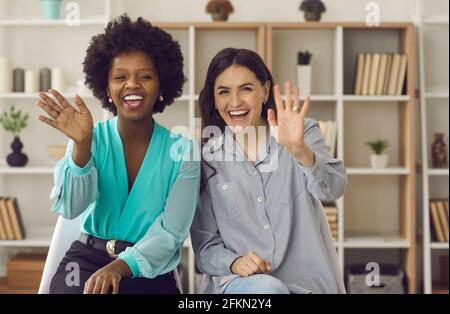 Les femmes d'affaires internationales agitant les mains saluant leurs collègues lors d'une conversation par appel vidéo. Banque D'Images