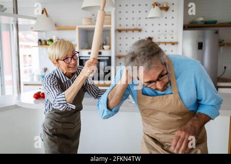 Querelle familiale. Un homme âgé contrarié et effrayé contre une femme en colère à la maison Banque D'Images