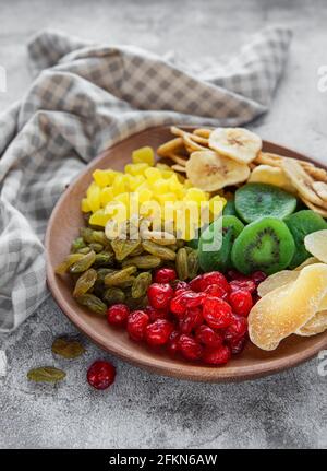 Bol avec divers fruits séchés sur fond de béton gris Banque D'Images