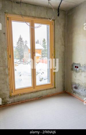 Intérieur d'un nouvel appartement avec des fenêtres en construction sans finition dans les tons sombres avec trous électriques et câblage pour le projecteur de plafond. Bonjour Banque D'Images