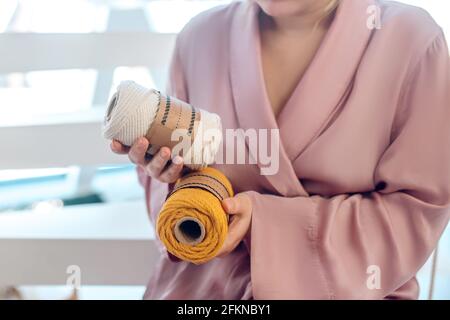 Femme dans une tenue de tête tenant le fil dans ses mains Banque D'Images