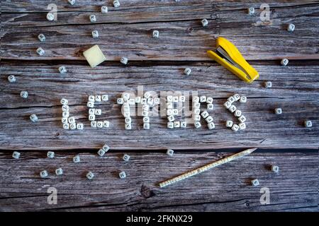 Dés en bois formant le mot lettres. Les dés sont sur une table en bois et à côté des fournitures de bureau. Banque D'Images