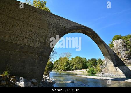 Paysage avec vue panoramique sur le pont en pierre unique construit historique au-dessus de la rivière Aoos à Konitsa, Epirus Grèce. Banque D'Images