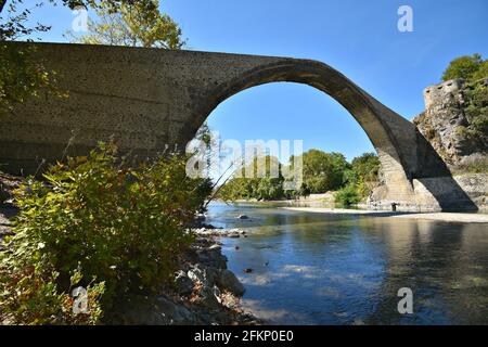 Paysage avec vue panoramique sur le pont en pierre unique construit historique au-dessus de la rivière Aoos à Konitsa, Epirus Grèce. Banque D'Images