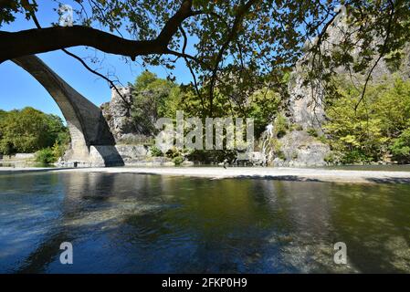 Paysage avec vue panoramique sur le pont en pierre unique construit historique au-dessus de la rivière Aoos à Konitsa, Epirus Grèce. Banque D'Images