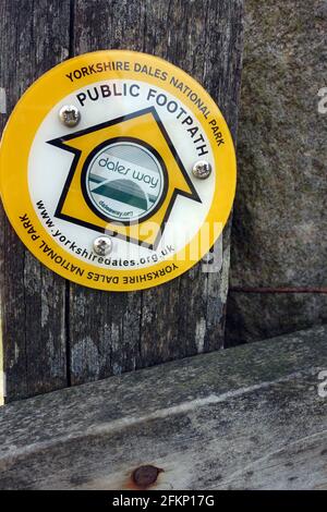 Yellow Round Metal Marker sur Gatepost près de Grassington sur le sentier longue distance de Dales Way dans le parc national de Yorkshire Dales, Angleterre, Royaume-Uni. Banque D'Images