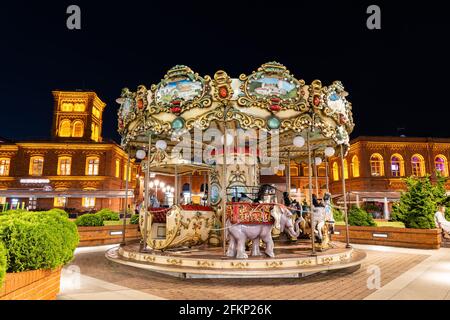 Carrousel ornemental de style viennois de nuit à Manufaktura (centre des arts, centre commercial et complexe de loisirs), ville de Lodz, Pologne Banque D'Images