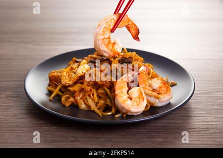 Une délicieuse nouilles de riz plat frites épicée, également connue sous le nom de « char kuew teow », célèbre parmi les malaisiens. Banque D'Images