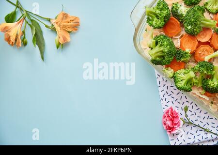 Bonne nutrition : brocoli, carottes et pâtes sur fond bleu pour la cuisson. Cuisine italienne et belles fleurs. Concept été lumineux avec espace de copie. Photo de haute qualité Banque D'Images