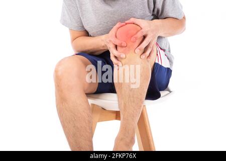 Douleur douloureuse au genou. Les symptômes de la pluie et de l'arthrite. Homme d'âge moyen tenant son genou blessé sur fond blanc. Banque D'Images