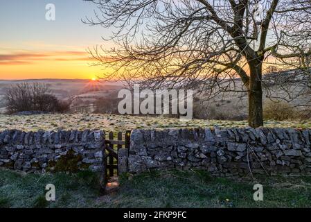 Matin glacial en avril avec mur et porte en pierre et lever du soleil, Peak District, Derbyshire, Royaume-Uni à Taddington près de Buxton et Bakewell Banque D'Images