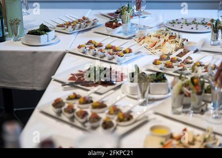 Banquet de mariage. Une variété d'en-cas, salades, plats de poisson, tartelettes sur une nappe blanche sur la table Banque D'Images