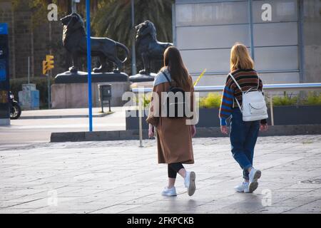 Vue arrière de deux jeunes femmes marchant dans une rue. Barcelone, Catalogne, Espagne. Banque D'Images