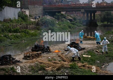 Katmandou, Népal. 03ème mai 2021. Les travailleurs népalais portant des combinaisons de protection crémate les cadavres de victimes du coronavirus (COVID-19) dans les locaux du temple de Pashupatinath.le crématorium électronique situé à Pashupati est congestionné par les cadavres de mort de COVID-19 arrivant pour la crémation. Comme il n'y a pas d'espace à l'intérieur du crématorium en raison d'une capacité limitée, des corps de mort du défunt sont brûlés près de la rive de la rivière Bagmati, dans les locaux du temple de Pashupatinath. Crédit : SOPA Images Limited/Alamy Live News Banque D'Images