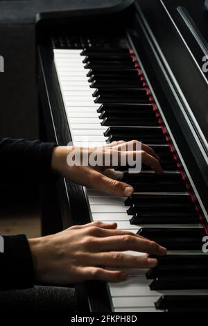 Deux mains sur un clavier de piano, photo verticale en noir et blanc Banque D'Images