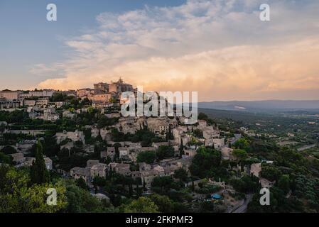 Village de Gordes sur une colline au coucher du soleil avec la vallée en arrière-plan Banque D'Images