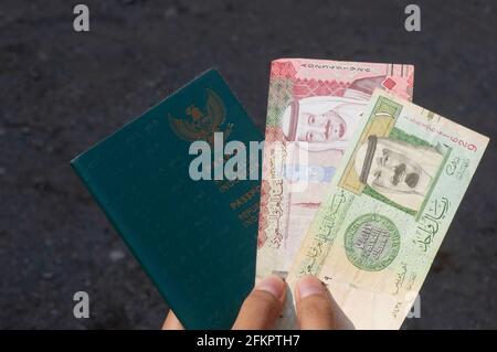 Passeport vert indonésien et le Riyal saoudien, la monnaie de l'Arabie Saoudite, concept de la préparation des pèlerins et du hadj de l'Indonésie, en s. Banque D'Images