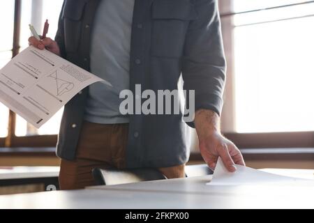 Photo rognée d'un professeur d'université méconnaissable présentant des documents d'examen dans un auditorium d'école éclairé par la lumière du soleil, espace de copie Banque D'Images