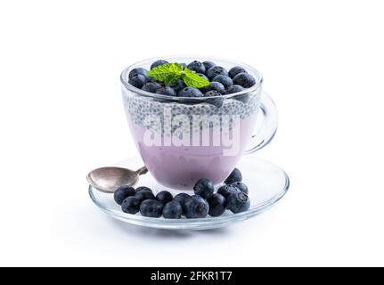 Yogourt aux bleuets violets et aux baies fraîches graines de chia en verre tasse isolée sur blanc Banque D'Images