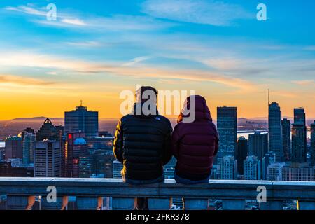 Vue arrière d'un couple assis l'un à côté de l'autre Sur le mur en pierre du belvédère de Kondiaronk et de ses amiring La vue colorée sur les gratte-ciel de Montréal Banque D'Images