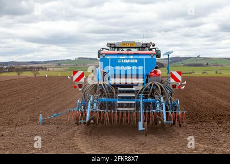 Un tracteur labourant un champ à Fife au début du printemps Banque D'Images