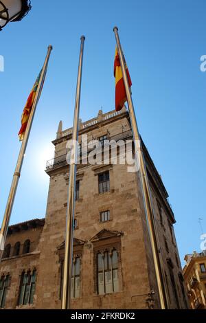 Coucher de soleil derrière un bâtiment historique en pierre rouge en Espagne, vu de la cour avec les drapeaux espagnols Banque D'Images