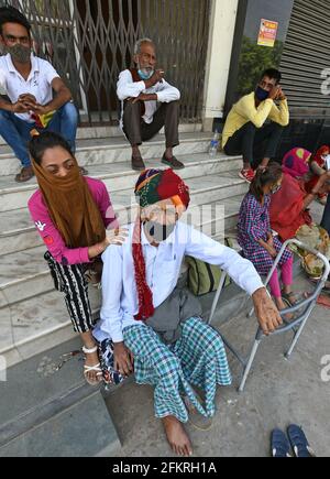 Beawar, Rajasthan, Inde, 3 mai 2021 : homme âgé assis dans les escaliers devant la State Bank of India pour le paiement de la pension le premier jour ouvrable de mai lors du confinement imposé par le gouvernement pour freiner l'augmentation des cas de coronavirus à Beawar. Crédit : Sumit Saraswat/Alay Live News Banque D'Images