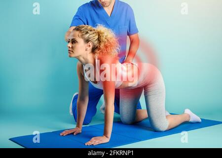 Fille effectue des exercices avec un physiothérapeute. Fond cyan Banque D'Images