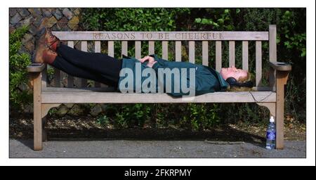 Un banc commémoratif à Ian Dury, à l'angle des poètes, Pembrook Lodge, Richmond Park. Jane Mills aime le soleil et la musique de Dury en branchant son casque dans les prises dans les accoudoirs de ce banc spécial.pic David Sandison 29/4/2002 Banque D'Images