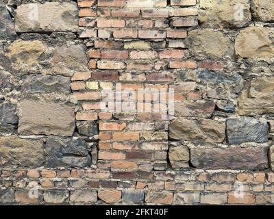 mur de jardin de fort vintage fait de briques de bloc fissurées et recouvert de mousse Banque D'Images
