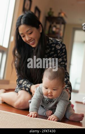 Baby Girl sitting on floor with mother Banque D'Images