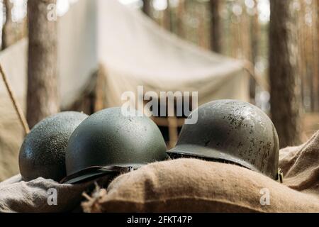 Casques métalliques du soldat d'infanterie de l'armée des États-Unis à la Seconde Guerre mondiale Casques près de la tente de camping dans le camp forestier Banque D'Images