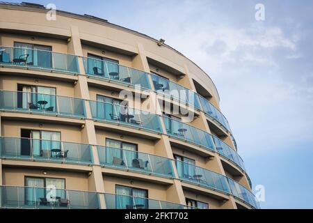 Un bâtiment résidentiel avec des balcons plats et identiques avec des climatiseurs déchirés et du verre. Motif de balcon Banque D'Images