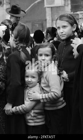 Des enfants orthodoxes juifs attendent en file pour de la nourriture et des bonbons servis par un homme juif juste pendant les préparatifs de la Pâque à MEA She'arim Jérusalem. Banque D'Images