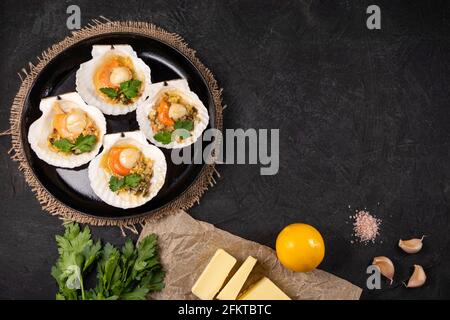 Recette pour la cuisson des pétoncles avec caviar. Pétoncles cuits avec caviar et sauce crémeuse à l'ail. Pétoncles, citron, ail, persil, beurre et sel. Haut vi Banque D'Images