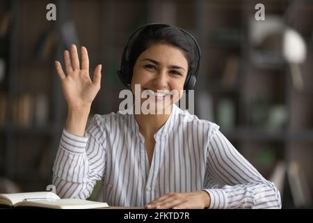 Portrait de tête souriant femme indienne dans un casque agitant la main Banque D'Images