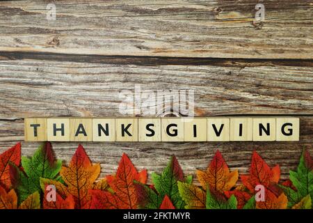 Bonne lettre de l'alphabet Thanksgiving avec des feuilles d'automne sur fond en bois Banque D'Images