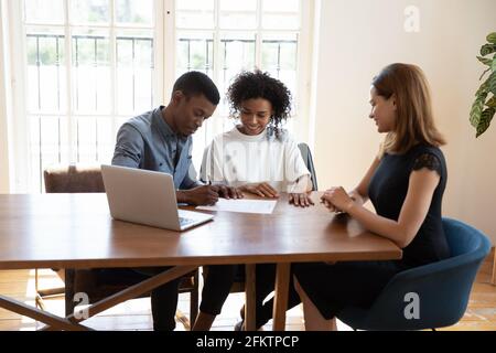 Couple familial afro-américain souriant signant le contrat. Banque D'Images