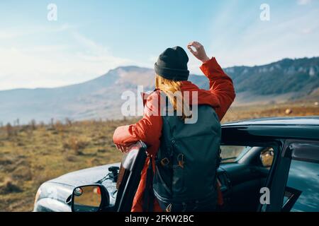 une femme voyage dans la nature avec un sac à dos et près du voiture Banque D'Images