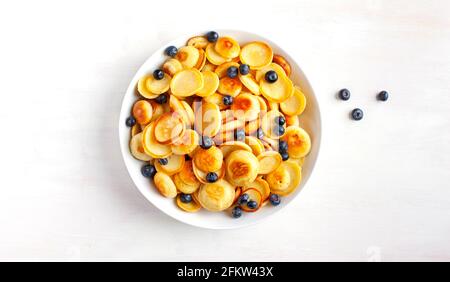 Plats tendance - céréales à crêpes. Petit déjeuner maison avec de minuscules crêpes et baies. Vue de dessus. Banque D'Images