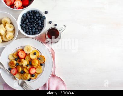 Plats tendance - céréales à crêpes. Petit déjeuner maison avec de minuscules crêpes et baies. Vue de dessus. Banque D'Images