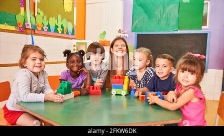 Bonne enseignante de maternelle et enfants multiculturels dans la maternelle internationale Banque D'Images