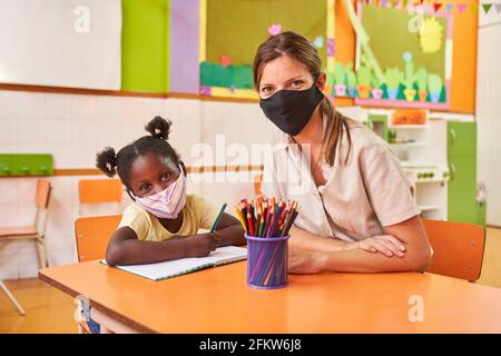 Enfant et fille africaine avec masque en raison de Covid-19 in garderie ou préscolaire Banque D'Images