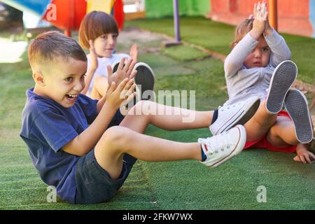 Les enfants s'amusent à faire de la gymnastique ou de l'aérobic en physique classe d'éducation à l'école primaire Banque D'Images